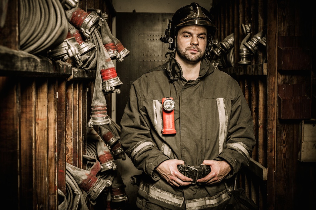 Firefighter in storage room with fire hoses; International Association of Firefighters