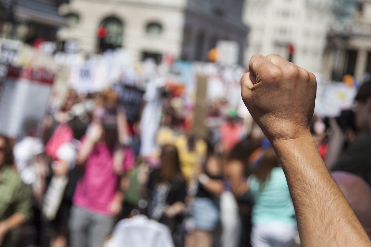 A raised fist of a protestor at a political demonstration; representing the International Association of Machinists and Aerospace Workers