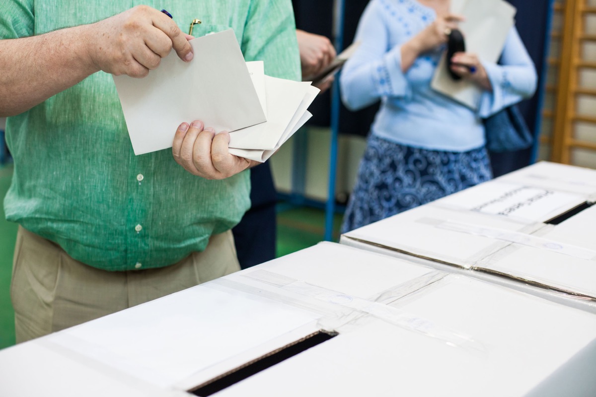 A person prepares to cast a ballot at a polling station during voting; NLRB certification concept