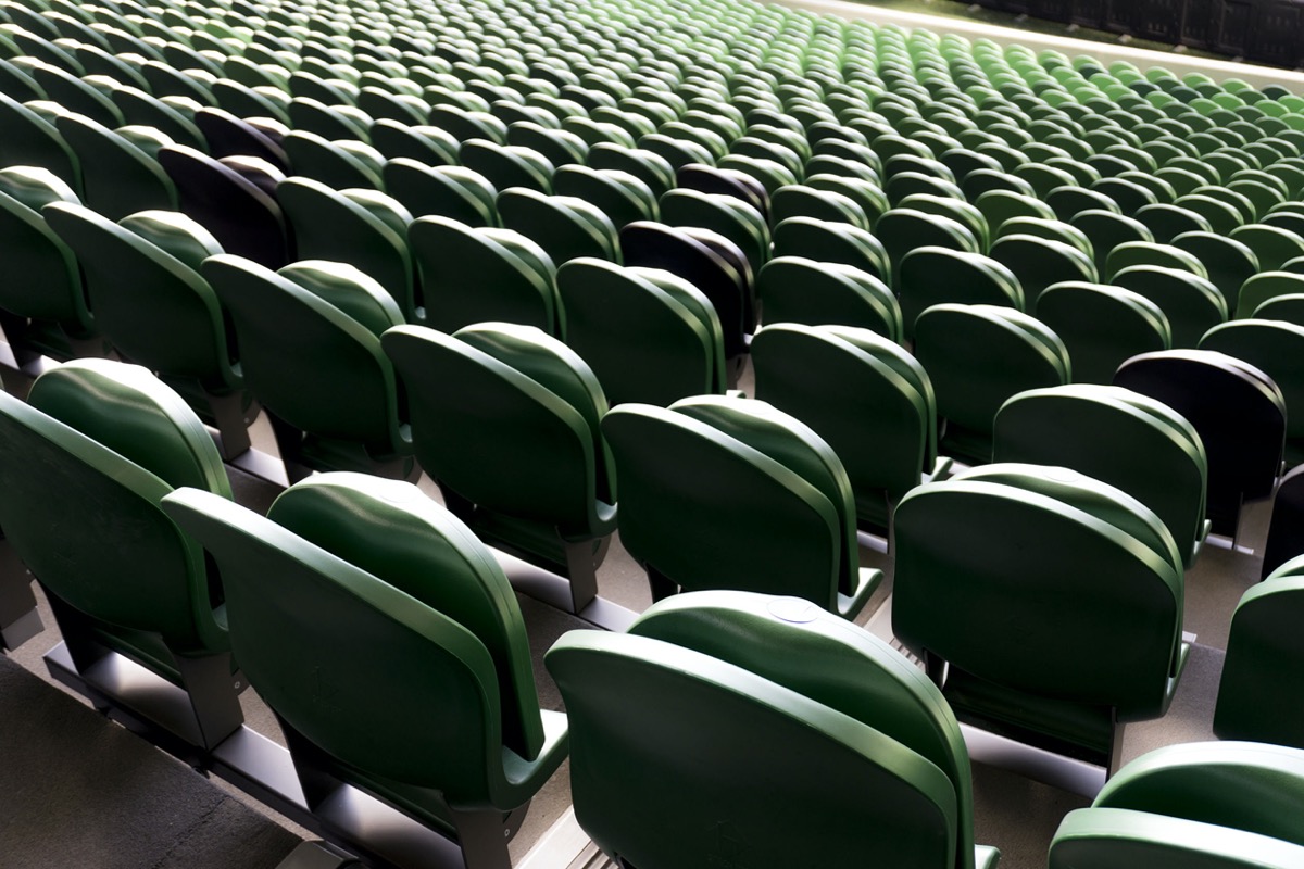 Empty plastic seats in a university arena; reopening college concept