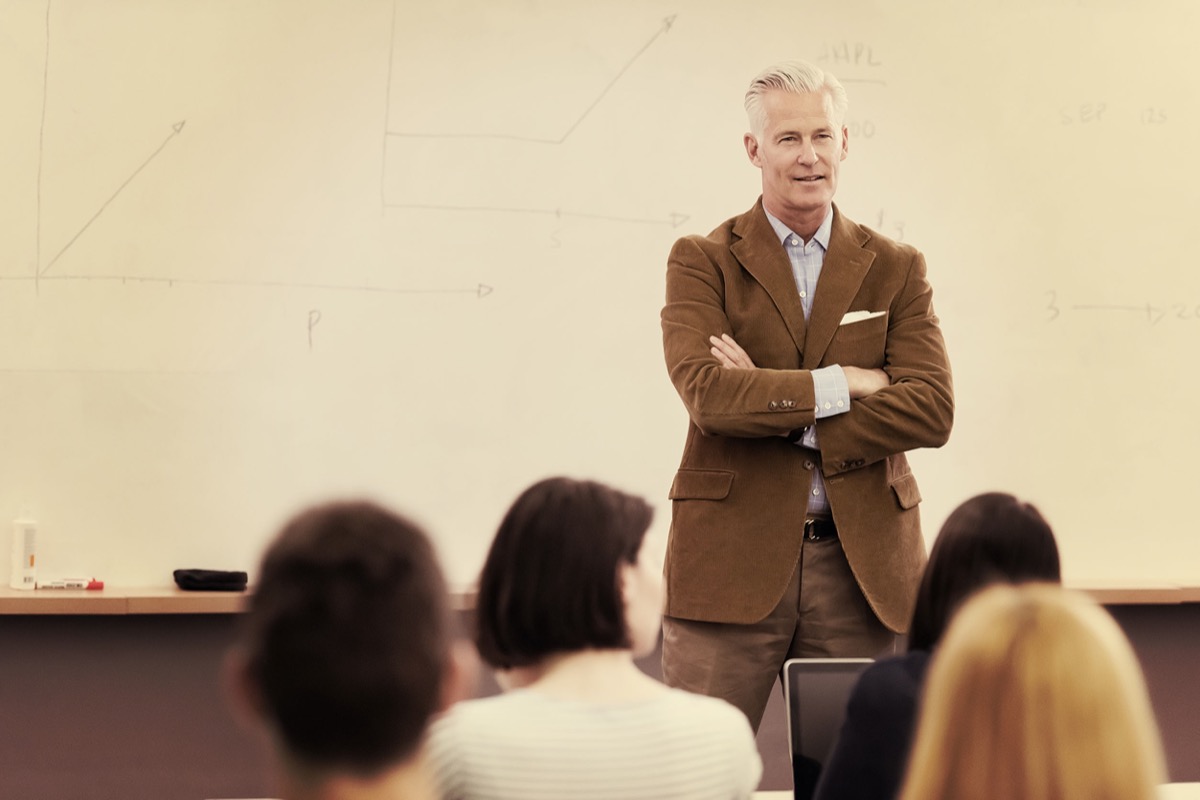 group of students study with professor in modern school classroom; reopening college concept