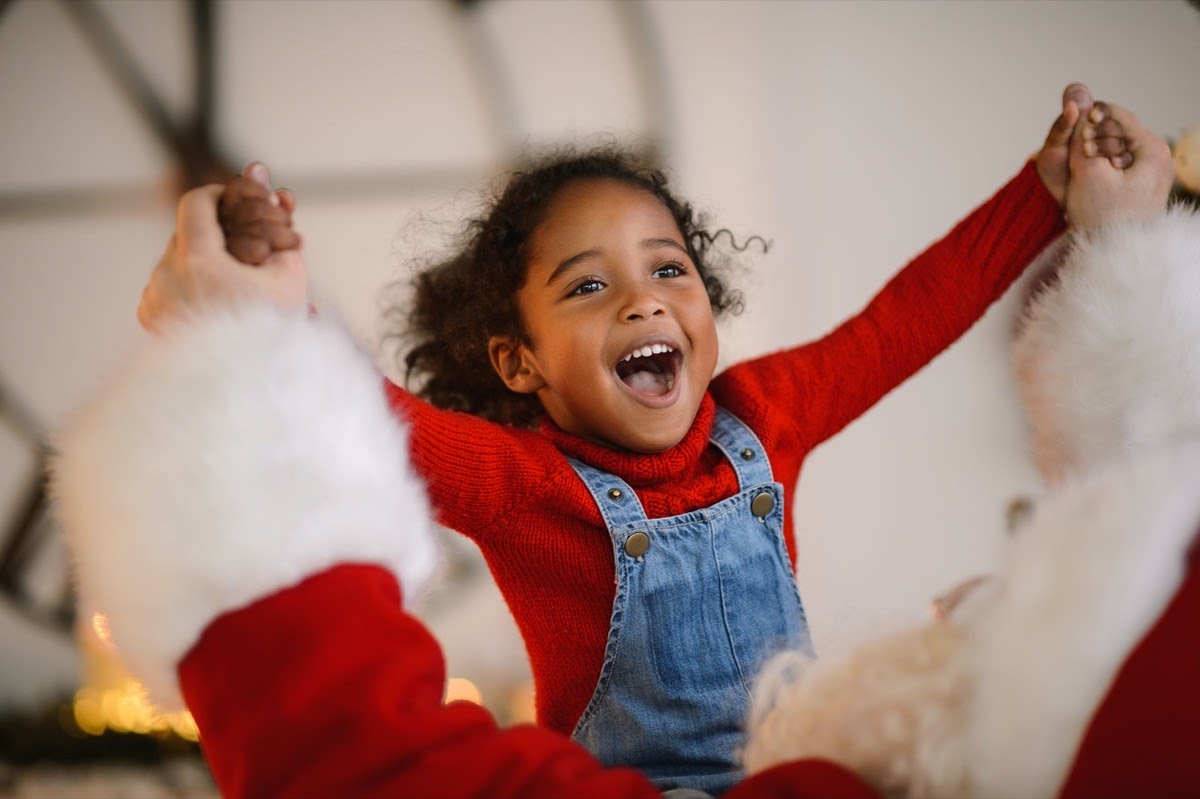 Santa Claus playing with cute african american Child at Home