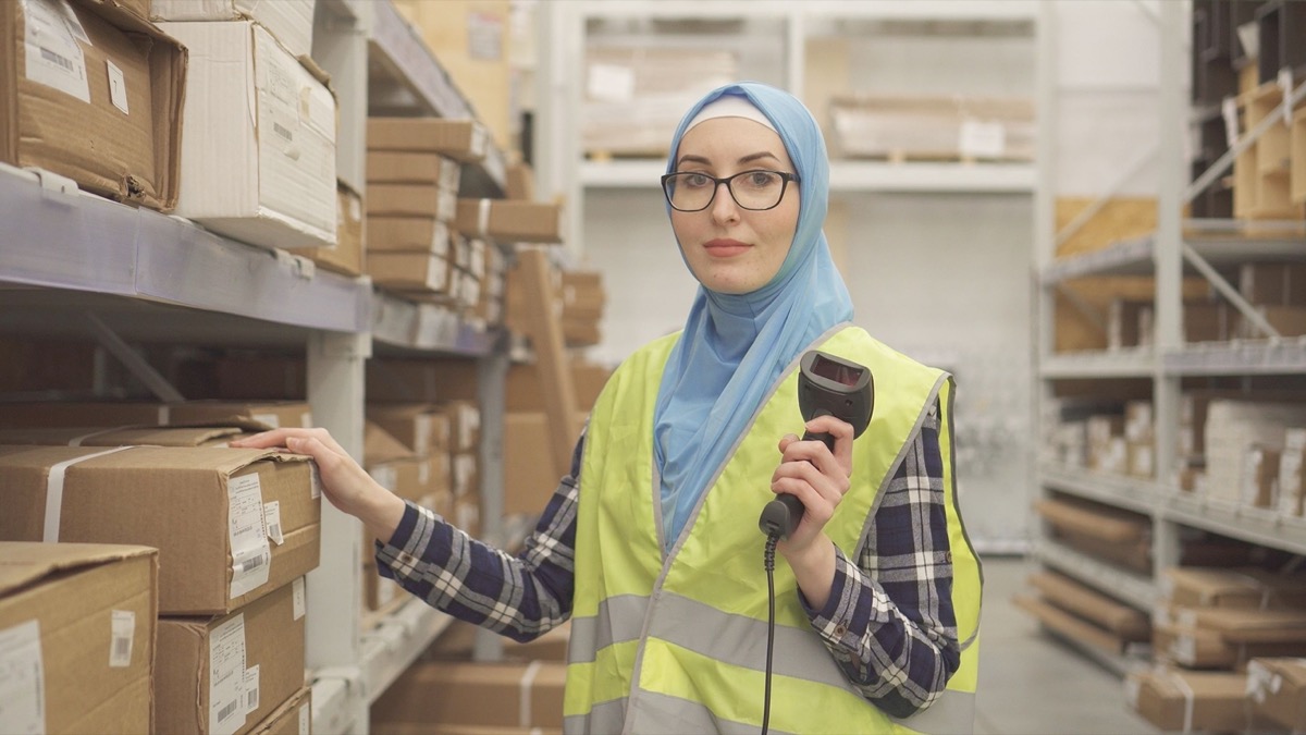 worker with barcode scanner in warehouse; concept: how 2020 online holiday shopping resulted in worker exploitation