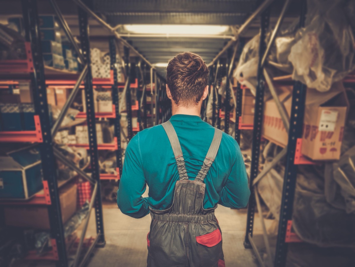 Worker on a automotive spare parts warehouse; Automotive workers and COVID concept.