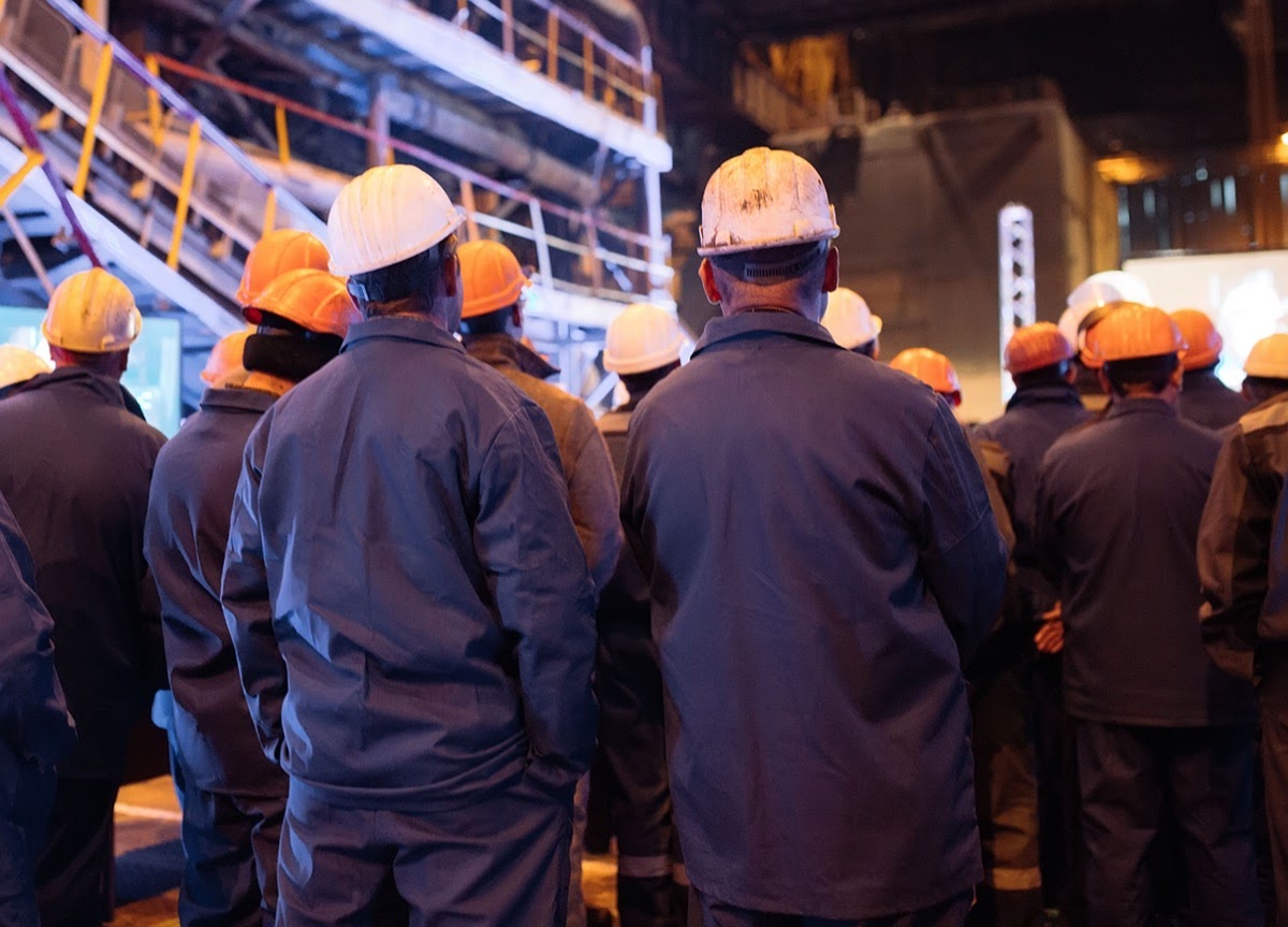 workers in hard hats outside a factory; concept: labor rights and the Biden Administration