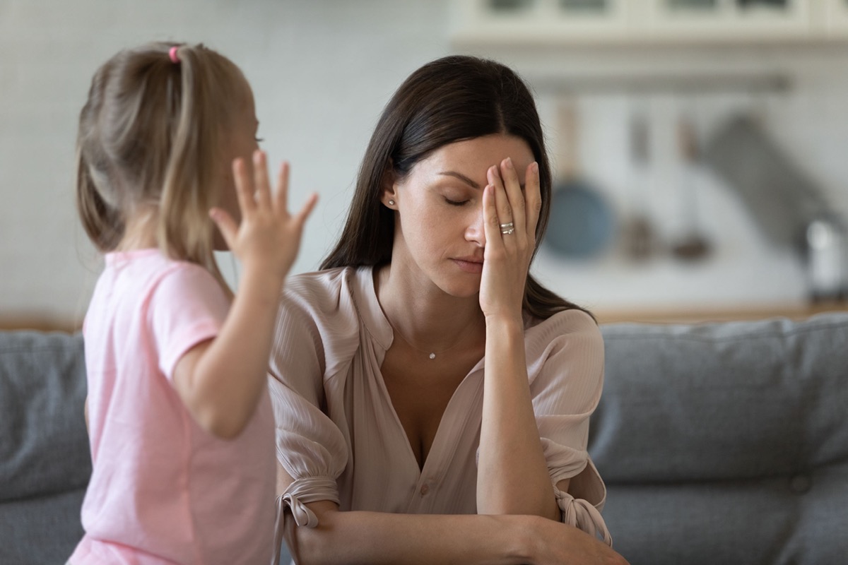 Tired mother appears stressed; working parents and school closures concept