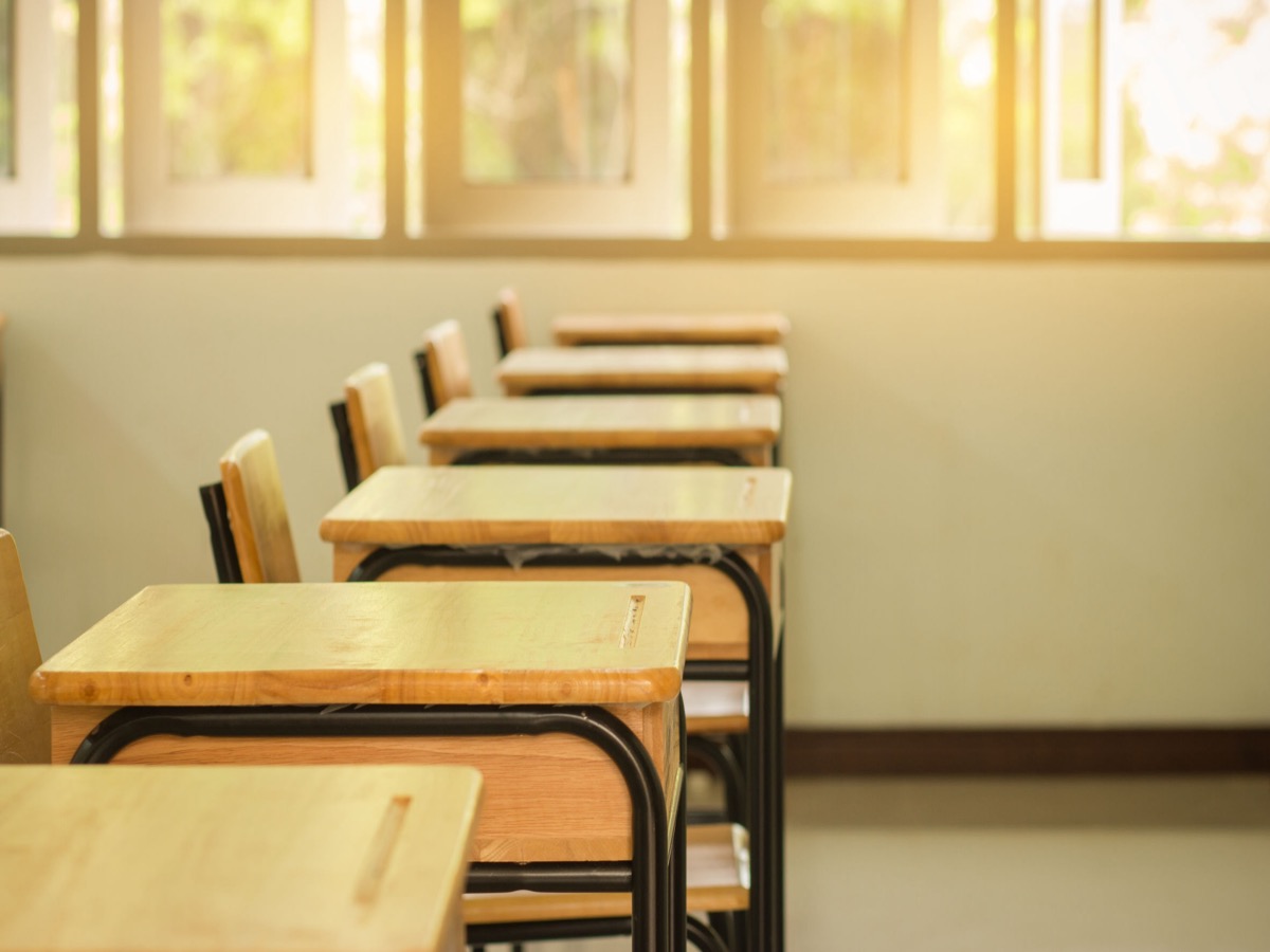empty classroom with desks and chairs; working parents and school closures concept