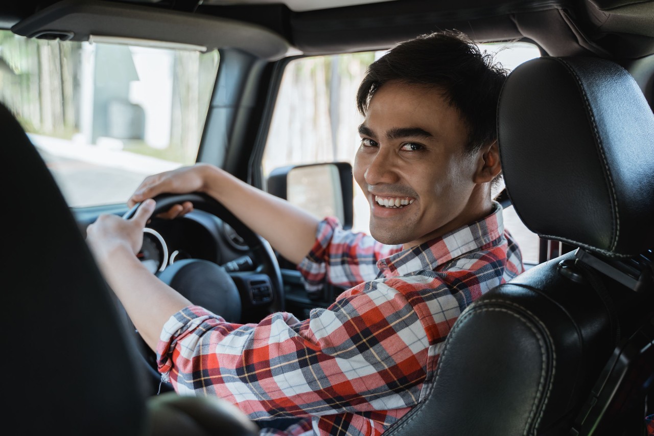 rideshare driver looks back over shoulder, smiling at passenger; uk uber drivers ruling concept