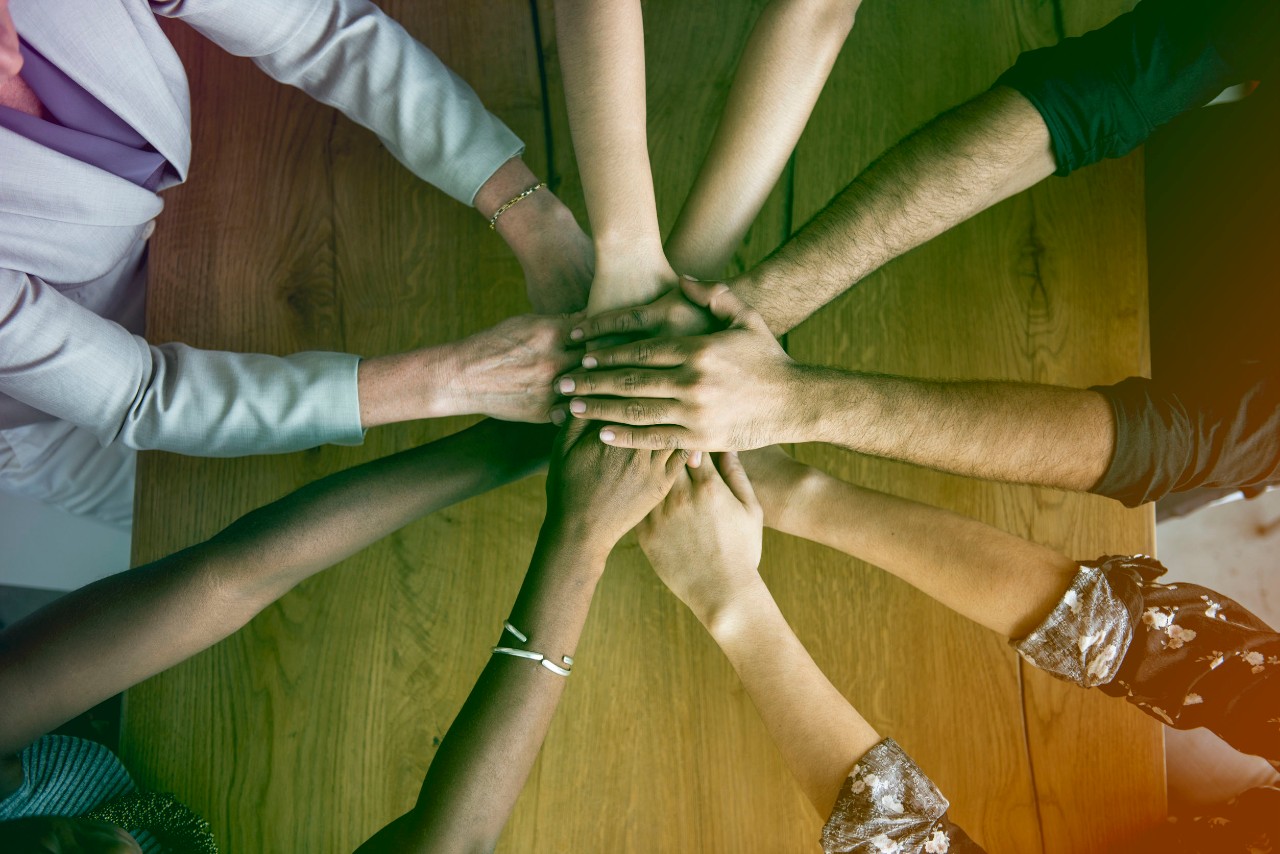 group of people extend hands to meet in center of a circle: Successful Union Drives in Spring 2021 concept