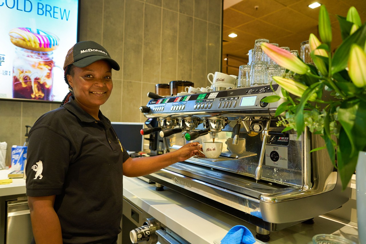 smiling fast food worker makes coffee; fight for $15 concept