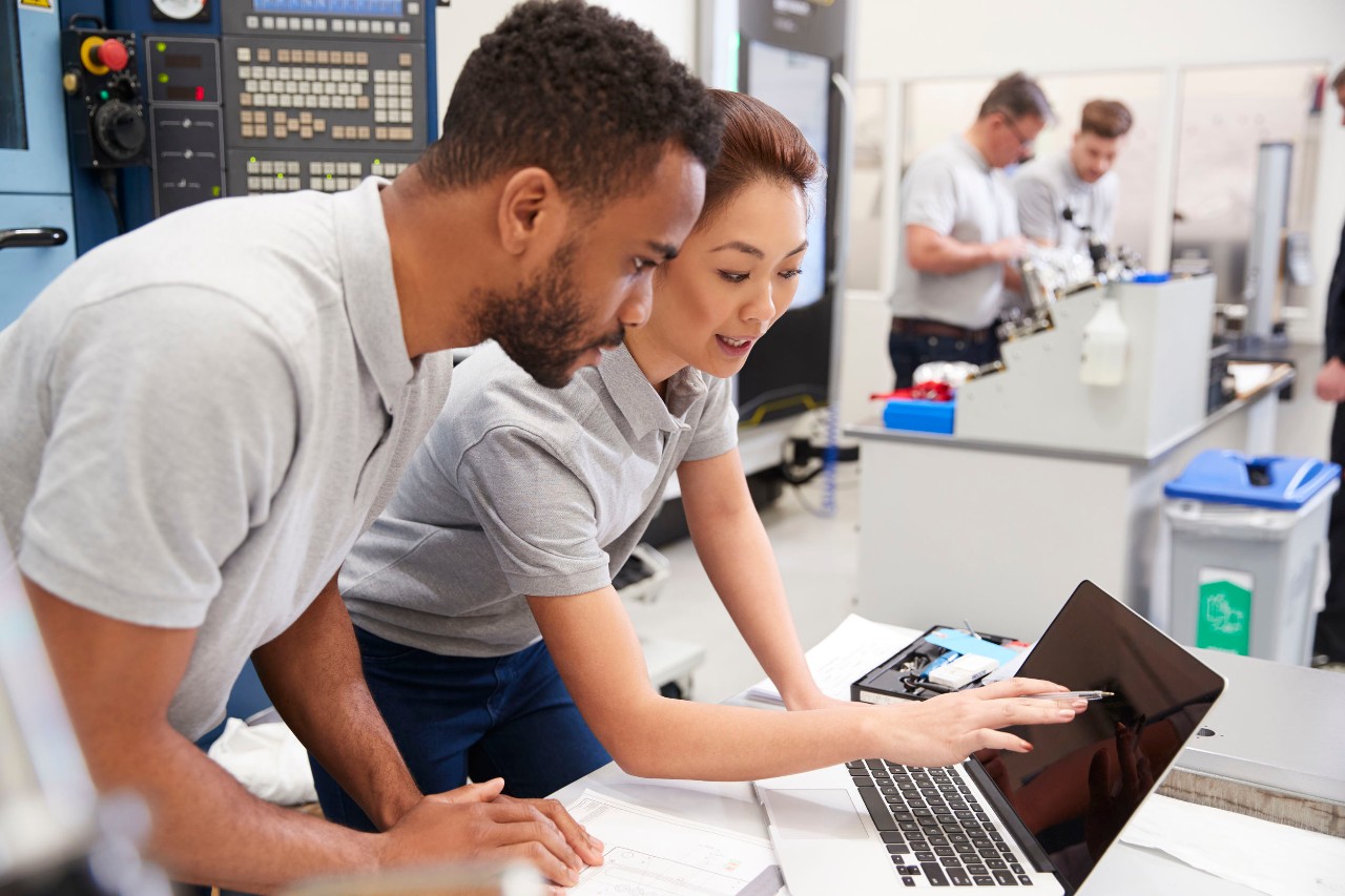 two labworkers share a laptop; big tech unions concept