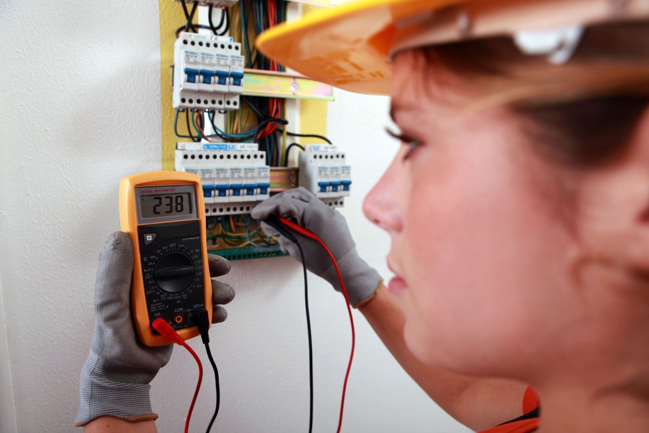 worker in hardhat using a voltmeter; labor influence on Biden administration concept