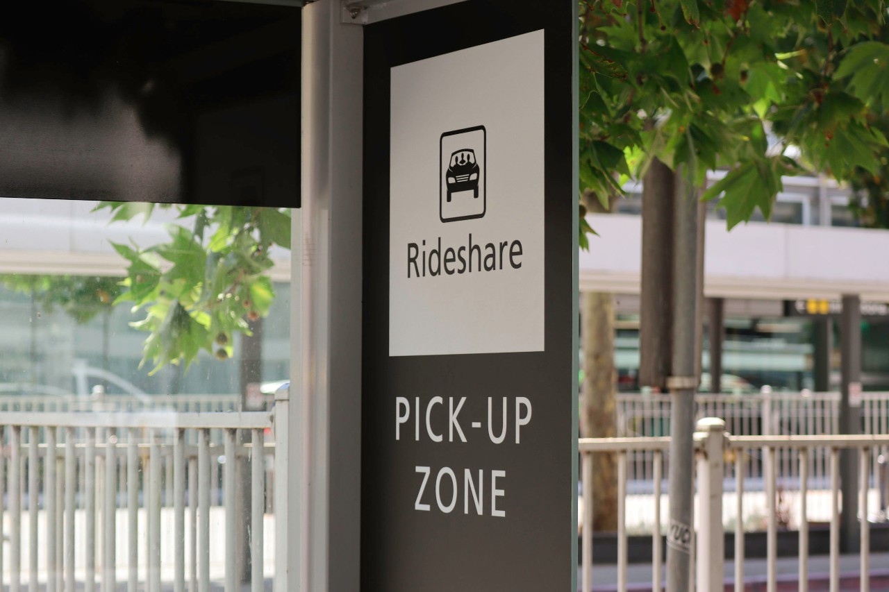 sign which says: "rideshare pickup zone"; unions, gig economy concept