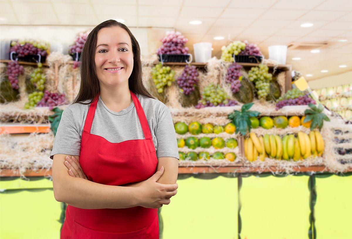 portrait of saleswoman at the fruits store with crossing arms; unions helping women return to work concept