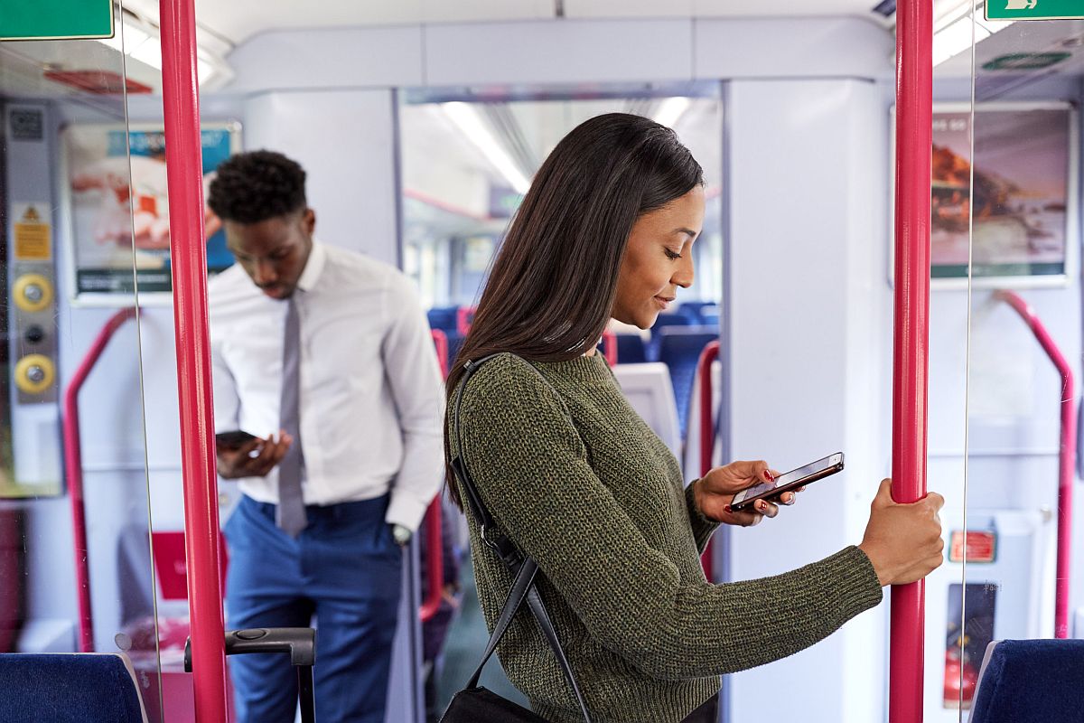 Workers Standing In Train Commuting To Work Looking At Mobile Phones; union email newsletters concept