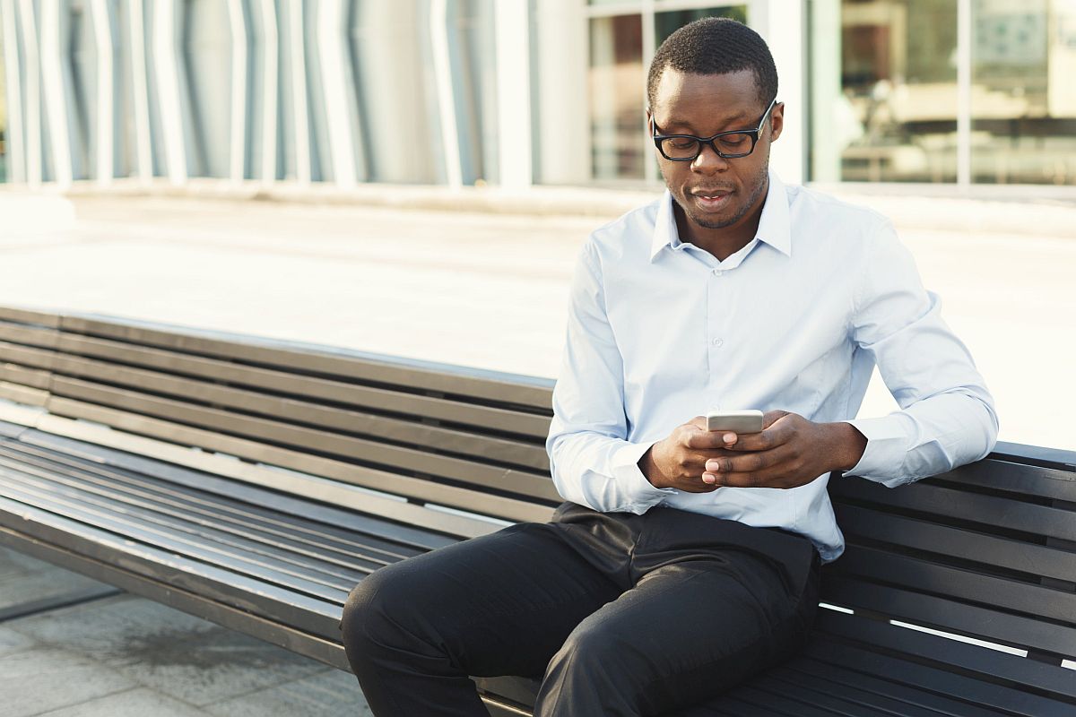 businessman texting on smartphone outdoors; Unionizing Your Workplace concept